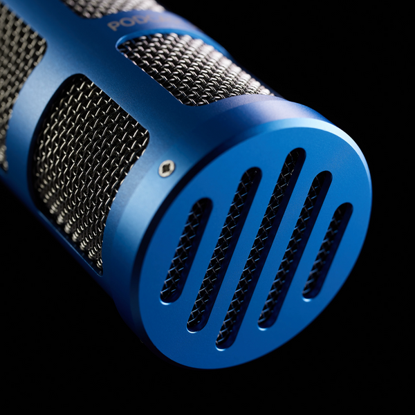 A close-up image on black background of a Sontronics Podcast Pro microphone in blue suspended and facing down towards the right, with its vintage-styled front grille in the foreground
