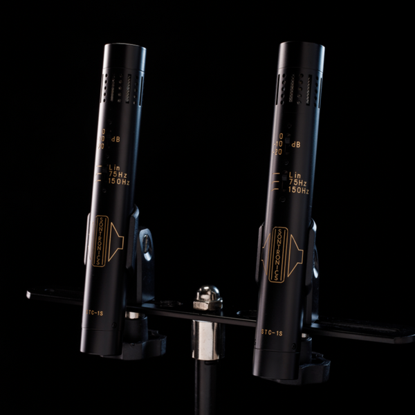 Image on a black background of two black Sontronics STC-1S microphones in their clips on their mounting bar tilted slightly to the right