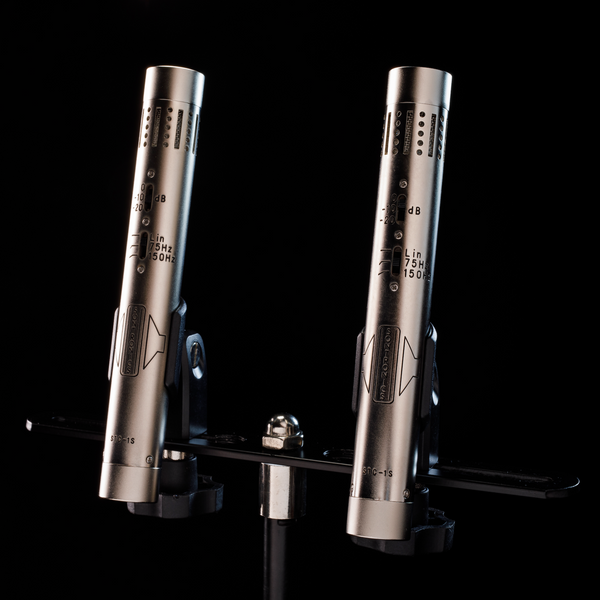 Image on a black background of two silver Sontronics STC-1S microphones in their clips on their mounting bar tilted slightly to the right