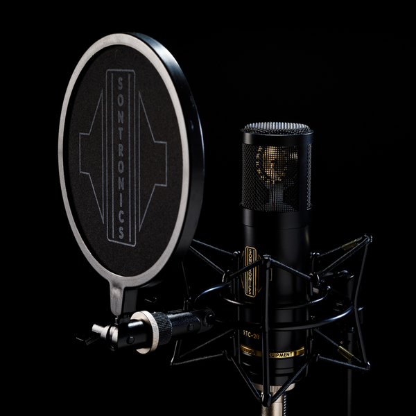 Image on black background with moody lighting showing a black Sontronics STC-20 microphone sitting in its spider shockmount facing to the left with the black circular nylon-mesh popshield in front of it showing the large white Sontronics logo 