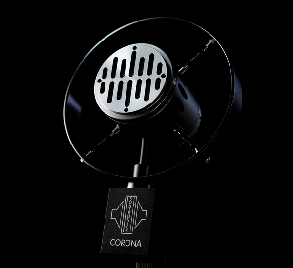 Image on black background with moody lighting of the Sontronics Corona microphones facing slightly upwards and to the left, with the recognisable outer ring and four springs supporting the central capsule body with its Art Deco design front grille