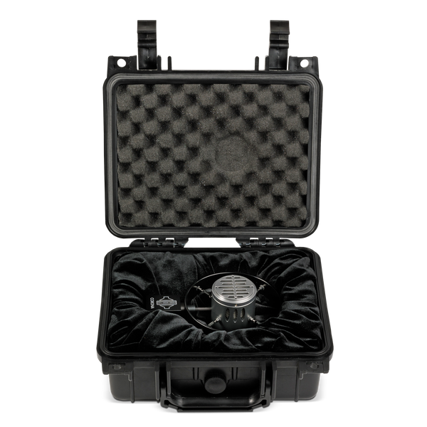 Image on white background of a small black flightcase with padded foam in the lid and velvet-lined bed, in which lies a Sontronics Corona microphone