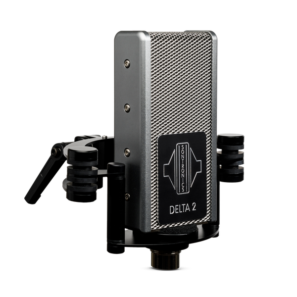 Image on white background of Sontronics Delta 2 microphone facing slightly to the right. The rectangular body with its silver mesh grille and silver side panels has a black plate on the front engraved with a silver logo and silver 'Delta 2' name. The microphone sits in its shockmount with two side supports and rear arcs, with the stand mount connector lever just visible